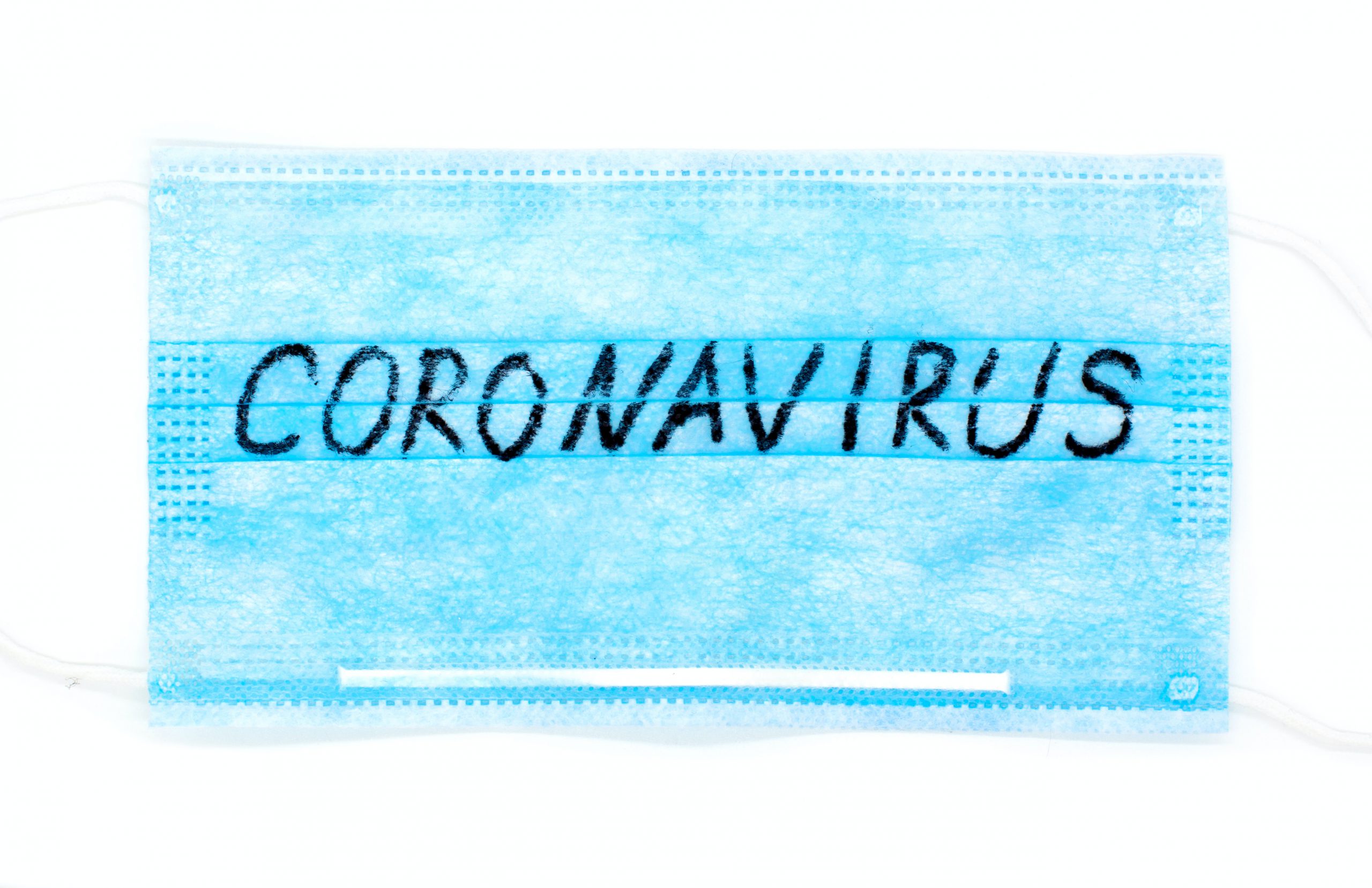 Afbeelding van een mondkapje met daarop het woord coronavirus geschreven